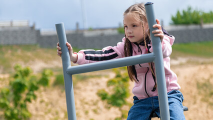 Obraz premium Sporty child girl doing morning workout on street sports ground. Fitness workout. a healthy family. street sports ground in a city park in casual clothes. Street workout