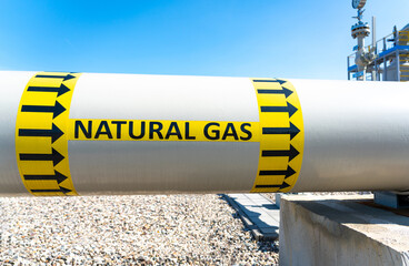 Natural gas pipeline with flow direction sign at compressor station. Concept of energy transportation infrastructure