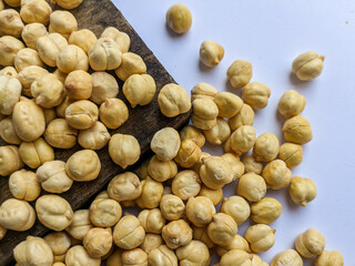 Raw chickpeas on a rustic wooden cutting board. Chickpea seed background. Seeds of legumes.