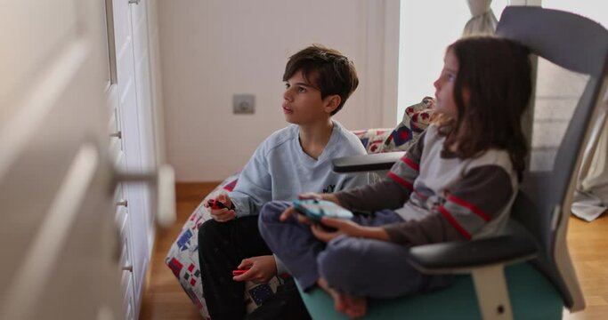 Boys intensely focused on his video game console. They are engrossed in the virtual world, oblivious to the surroundings.
