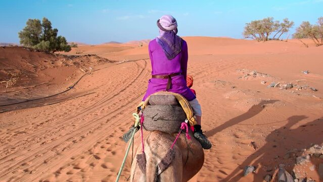 Camel ride, desert tour in Merzouga, Morocco, Erg Chebbi dunes and path for camping in the Sahara. Sunrises and sunsets to overnight destination in Berber desert camp