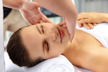 Closeup woman enjoying relaxing anti-stress head massage and pampering facial beauty skin...