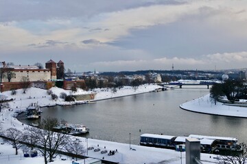 The Vistula River winds through Krakow and past the Wawel Castle. Its banks are covered in snow in January.