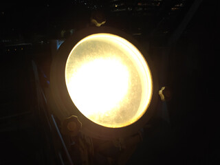An old searchlight burning at night