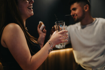 A group of friends sharing a happy moment together, playing pool and having drinks at a night bar.