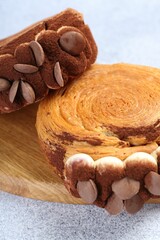 Supreme croissants with chocolate chips and cream on grey table, closeup. Tasty puff pastry