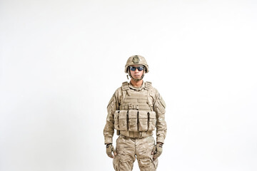 Portrait of a soldier in desert camouflage standing against a white background