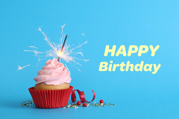 Birthday cupcake with sparkler on light blue background. Greeting card