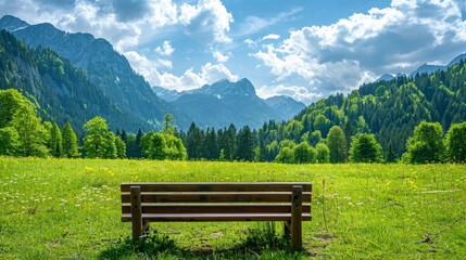 Peaceful bench in a meadow, green mountains and forest, bright blue sky with clouds, ideal for a copyspace image and creative banner