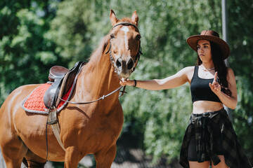 Young woman wearing a cowboy hat training a brown horse with a saddle in an outdoor setting on a...