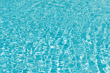 Obraz premium Pool side resort with pool water surface background. Sea ripples on blue pool background. Sea background. Swimming pool rippled. Summer vacation. Spa resort on summer vacation. Caribbean sea