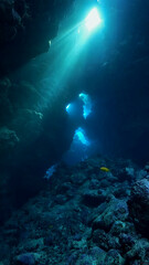 Underwater photo of rays of sunlight inside a cave. 