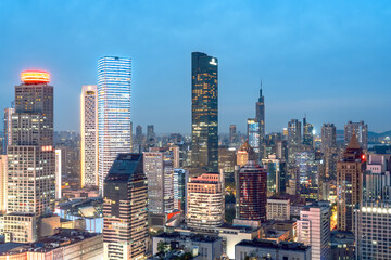 Naklejka premium City Skyline at Dusk with Illuminated Buildings