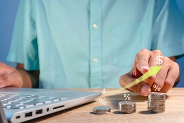 Man working with laptop to analyze business financial data report. Graph of increasing profit, revenue, price, sales, or interest.