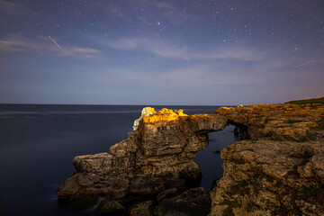 Rock in the Black Sea in the village of Tyulenovo, Bulgaria. Night photo. Star Sky.