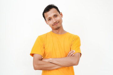 Fototapeta premium a young Asian man wearing a yellow t-shirt smiled and folded his arms across his chest. With a plain white background