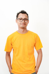 Fototapeta premium a young man wearing a yellow t-shirt, wearing glasses smiles facing the camera. With a plain white background