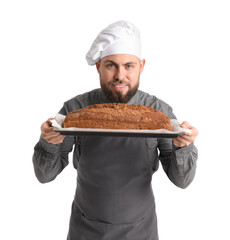 Male baker holding tray with rye bread on white background