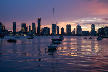 city skyline with boats at sunset