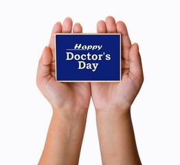 Happy Doctor's Day text written on blue background. hand holding card . 