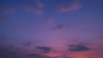 A serene sunset with a gradient of deep purples and soft pinks blending into a darker blue sky. Wispy clouds float gently, adding texture and depth to the tranquil scene. Cloud background.
