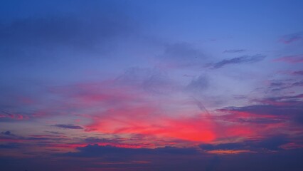 Fototapeta premium A beautiful sunrise with a captivating mix of deep blue, purple, and vibrant pink hues. The scattered clouds add depth and texture, creating a serene and mesmerizing scene. Sunrise sky background. 