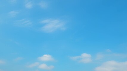 A clear blue sky with a few scattered white clouds. The soft, wispy clouds and the bright blue sky create a serene and tranquil atmosphere, evoking a sense of calm and peace. Cloud background.
