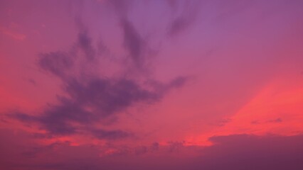 Obraz premium A stunning sunrise, with the sky drenched in vibrant pink and purple hues. Dark clouds create a striking contrast, adding drama and depth to the serene morning scene. Cloud background. 