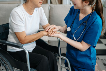 Obraz premium Asian caregiver doctor examine older patient woman therapist nurse at nursing home taking care of senior elderly woman sit on sofa.Medical service concept.