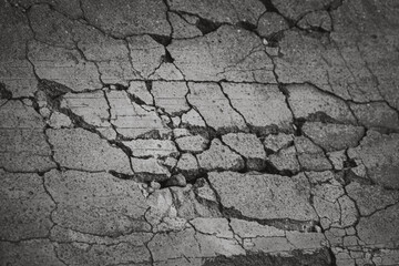 A cracked concrete surface with a lot of holes