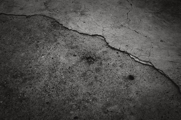 Obraz premium A black and white photo of a cracked concrete floor