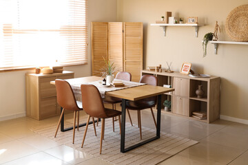 Dining table with reed diffuser, books and houseplant at home