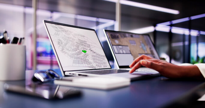 African American woman closely examining cadastral map on laptop screen