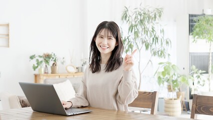 パソコンを使いながら指差しをする女性