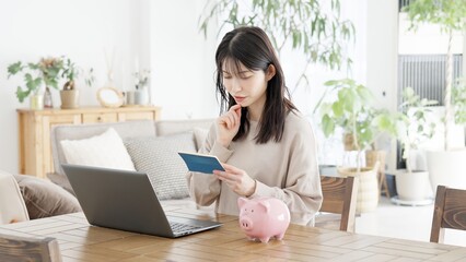 通帳の残高の心配をする女性