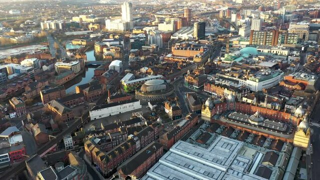 Aerial footage of the town centre of Leeds in West Yorkshire, flying around the Bridgewater Place tall building along side the Leeds Train Station on a cloudy day in the morning.