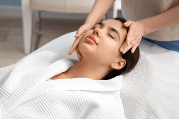 Beautiful woman having facial massage in salon, closeup