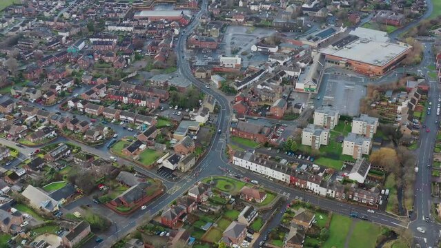 Aerial footage of the town centre of the town of Rothwell in West Yorkshire UK, showing the Main Street of the town and residential houses and shops with a large Morrisons supermarket and carpark.