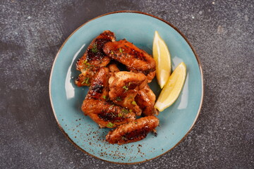 Grilled spicy chicken wings with herbs and lemon