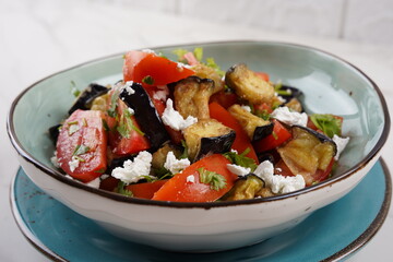 Salad of crispy fried eggplant and tomatoes, with Feta cheese,  Parsley