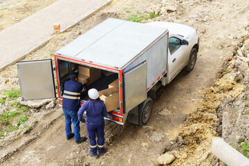 Two people are loading boxes into a truck