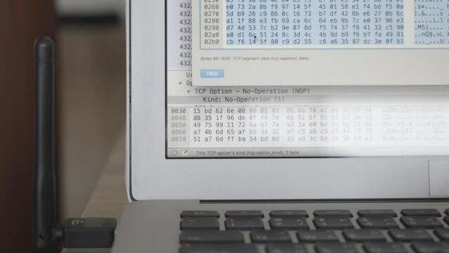 A laptop screen shows a lot of numbers and letters. The laptop is open to a page with a lot of information