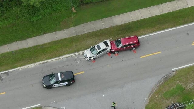 First responders personnel and vehicles responding to car accident site on American street in Florida. Emergency services helping victims of vehicle crash on road in USA.