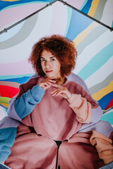 Young woman posing in hexagon mirrors on colorful background with kaleidoscope effect