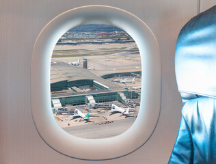 Fototapeta premium El Prat-Barcelona airport. This airport was inaugurated in 1963 as seen through window of an commerical passenger airplane - Barcelona, Spain