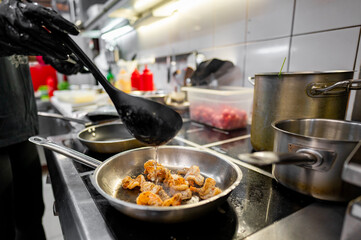 Sautéing shrimp in pan at busy restaurant kitchen, showcasing culinary skills and fresh ingredients.