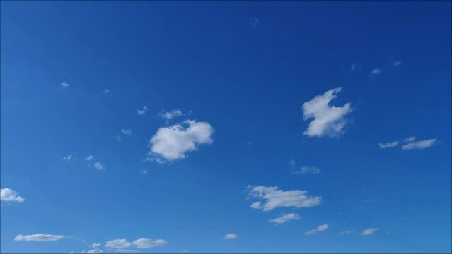 Curious and beautiful landscape of small clouds moving through the blue sky in the afternoon