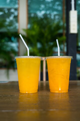 Couple showing a glass of iced passion fruit and iced orange juice in plastic cup. Concept of lover and healthy