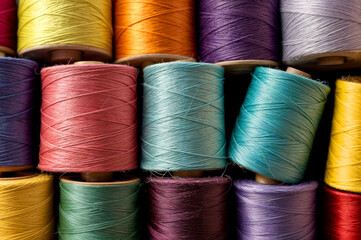 Set of colored threads for sewing on coils. Pile of big colorful spools of thread. Colored thread spools of thread large class, textiles, background