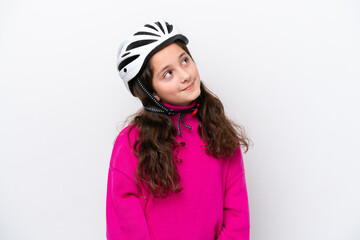 Little cyclist girl isolated on white background looking up while smiling